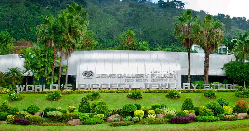 Phuket flagship facade with World's Biggest Jewelry Store sign, palms, and mountain backdrop